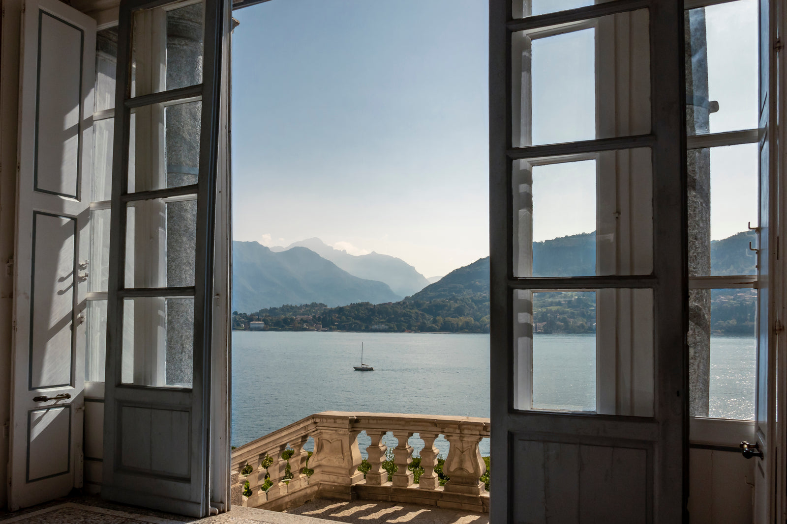 HY. FIFTY editorial view through open doors overlooking Lake Como and the surrounding mountains